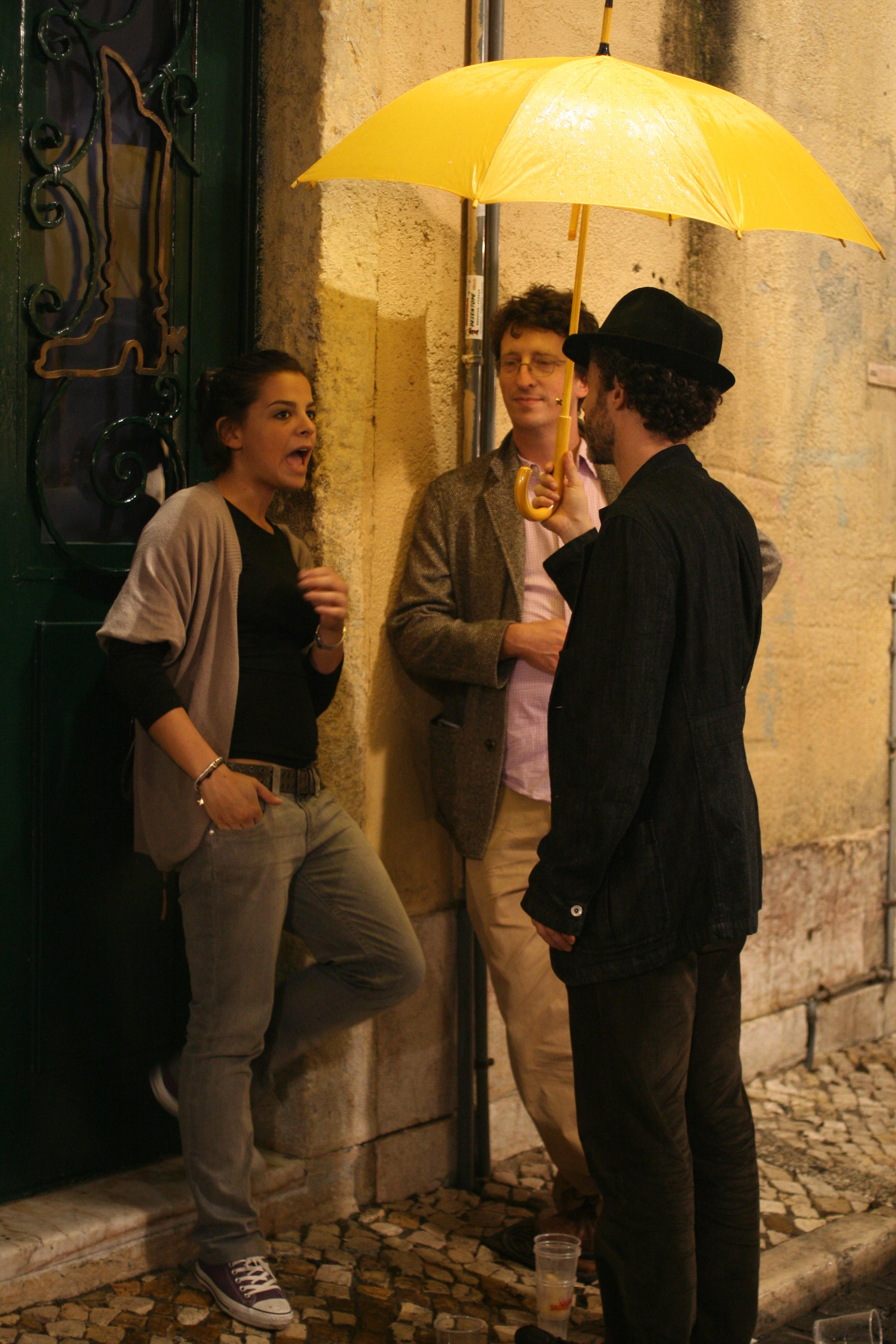 people standing under yellow umbrella