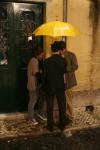 people standing under yellow umbrella